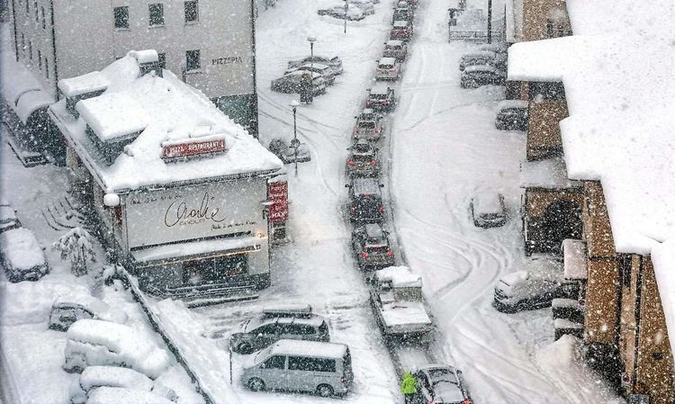Autokolonne steckt im Schnee fest.