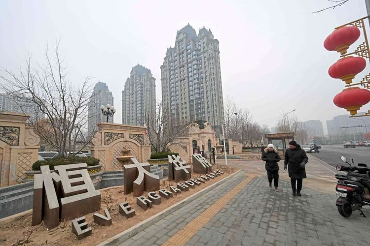 Menschen gehen an einem Wohnkomplex der Evergrande-Gruppe namens Evergrande Palace in Peking vorbei.