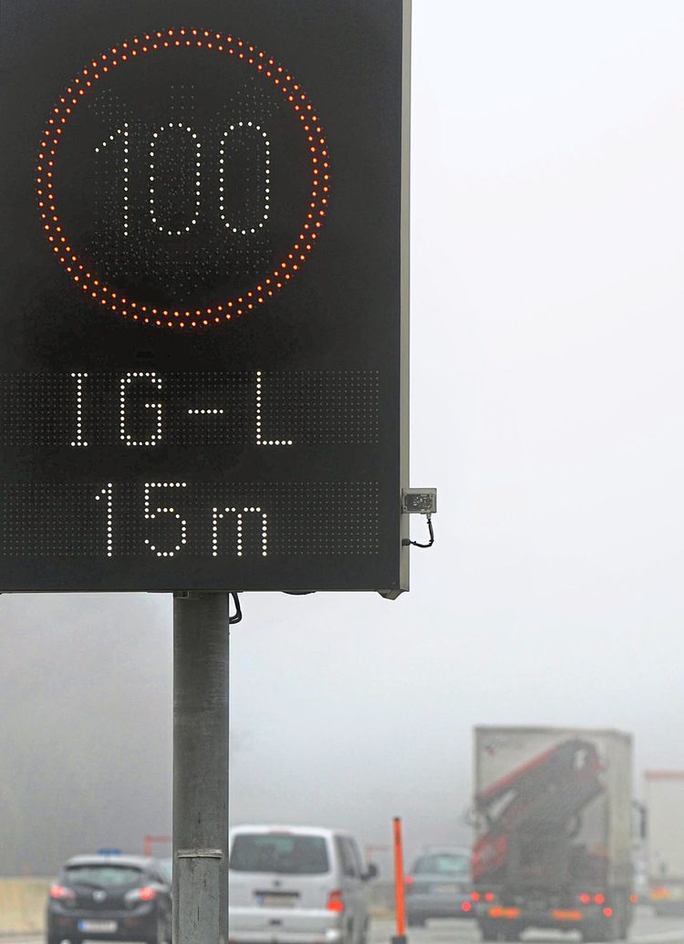 Pkws und Lkws im grauen Novembernebel unterwegs auf der Tauernautobahn. Höchstgeschwindigkeit ist aufgrund des Immissionsschutzgesetzes-Luft hundert km/h.