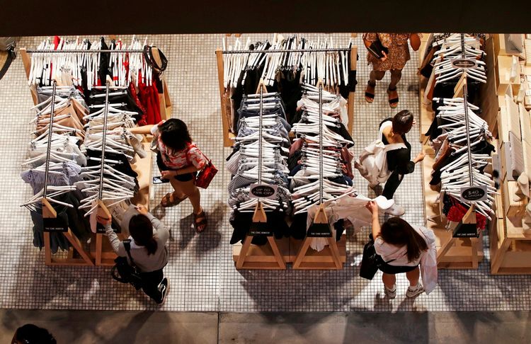 Frauen durchstöbern Kleidungsstücke auf Kleiderständern in einem Geschäft in einem Einkaufszentrum in Sydneys zentralem Geschäftsviertel (CBD), Australien. Ansicht von oben, aufgenommen am 5. Februar 2018.