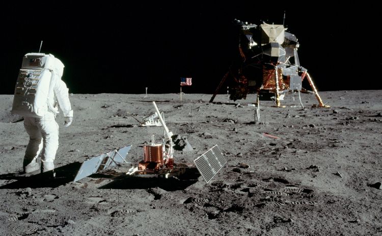 Ein Astronaut neben dem Seismometer, mit der Mondlandefähre im Hintergrund.