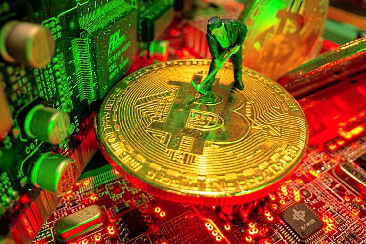 Eine kleine Spielzeugfigur und eine symbolische Bitcoin-Münze stehen auf einem Motherboard.