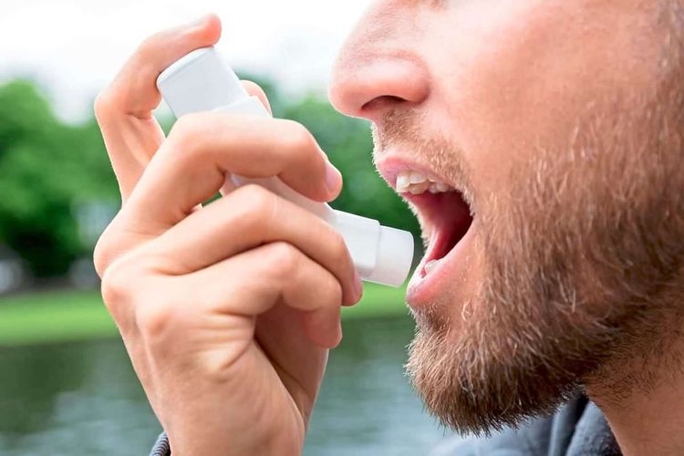 Closeup von Mann, der im Freien Asthmaspray inhaliert
