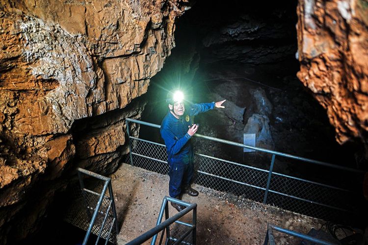 Paläoanthropologe Lee Berger in der Rising-Star-Höhle in Südafrika, seine Stirnlampe leuchtet in die Kamera.