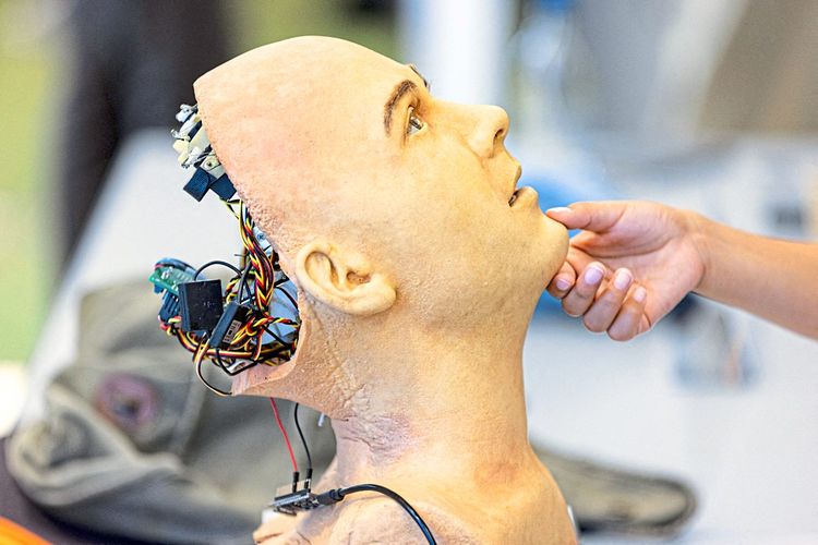 Der Torso eines humanoiden Roboters mit sichtbaren Kabeln auf der Rückseite des Kopfes.