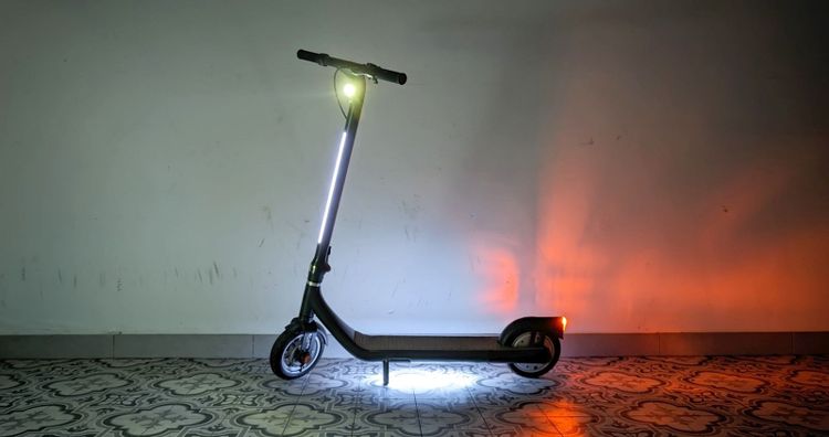 Ein E-Scooter mit eingeschalteter Beleuchtung.