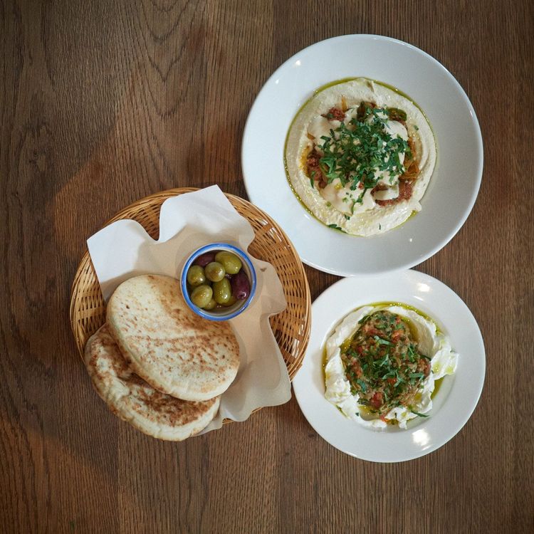 Fluffige Pita, Oliven und Hummus, sowie cremiges Labneh, das durch rauchig gegrillte Melanzani veredelt wird.