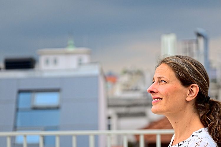 Porträt der dänischen Kommunikationswissenschafterin Stine Lomborg, dahinter dunkle Wolken