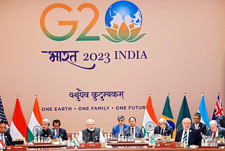 Mehrere Staatenvertreter sitzen. Groß über ihnen steht G20.