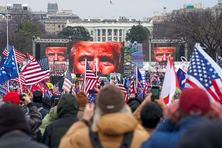 USA Flaggen vor Bildschirmen mit Donald Trumps Gesicht