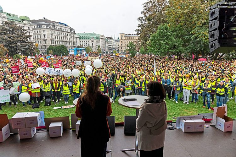 Streikende Kinderpädagoginnen und Kinderpädagogen vor eine Bühne im Wiener Votivpark