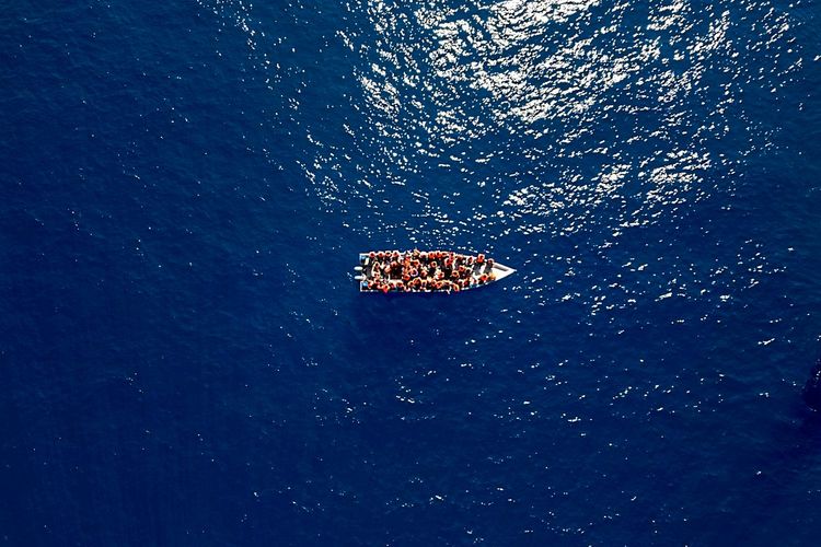 Migranten auf einem Holzboot im Mittelmeer