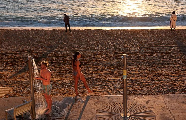 Am Strand von Barcelona baden Mitte Jänner mehrere Leute.