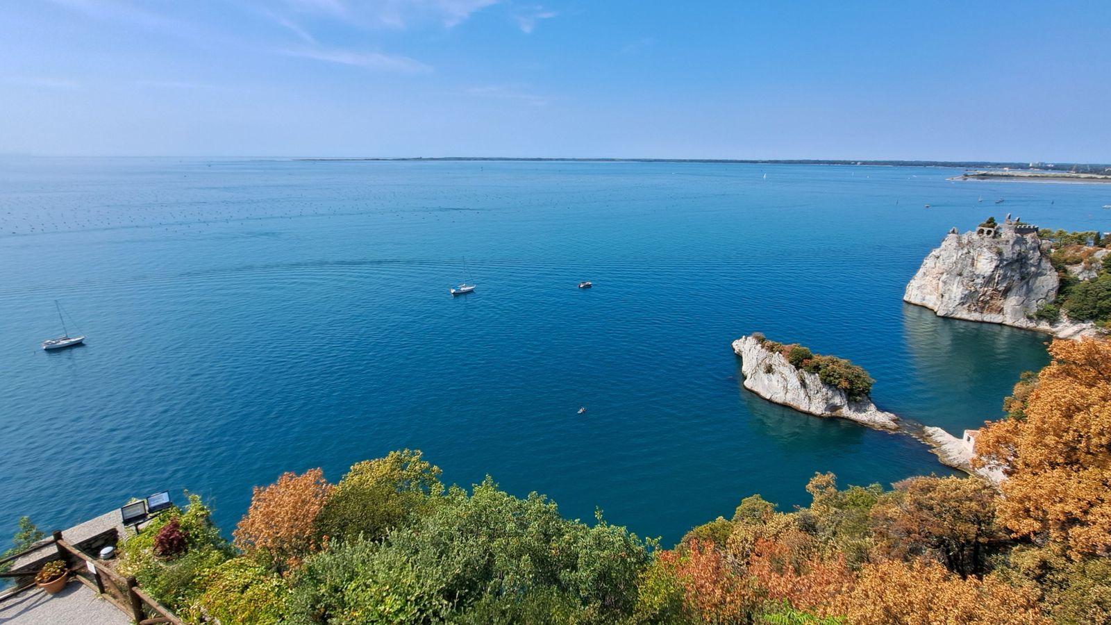 Blick auf das offene, blaue Meer, Klippen und Booten im Wasser