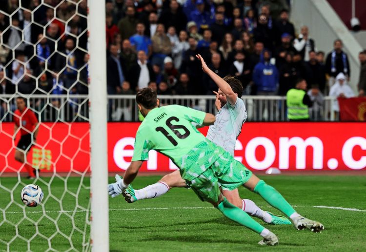 Österreichs Michael Gregoritsch (rechts) schießt auf das Tor, während Kosovos Torhüter Amir Saipi (links) versucht, den Ball zu halten, während eines UEFA-Nations-League-Spiels in Pristina, Kosovo. Zuschauer und ein Schiedsrichter sind im Hintergrund zu sehen.
