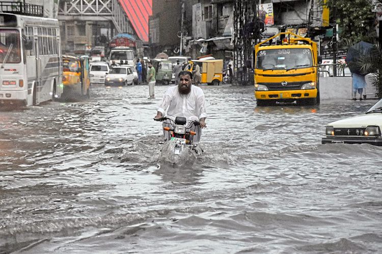 Ein Motorradfahrer trotzt den Wassermassen in Rawalpindi, Pakistan.