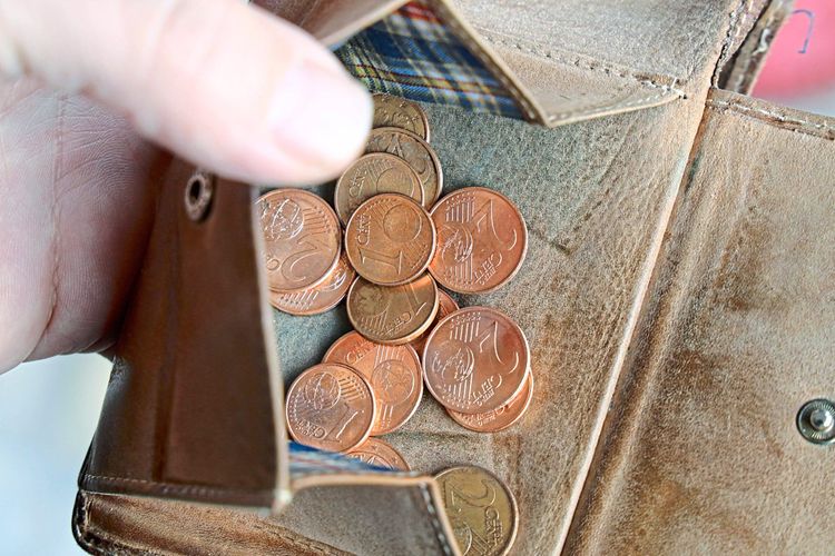 Eine geöffnete Brieftasche mit einigen Cent-Münzen drinnen.