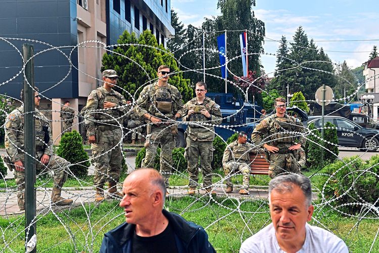 Kfor-Soldaten, Stacheldraht und Einwohner des Kosovo.