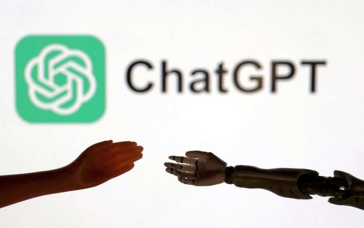 Menschlicher Arm und jener eines Roboters vor einem ChatGPT-Logo.