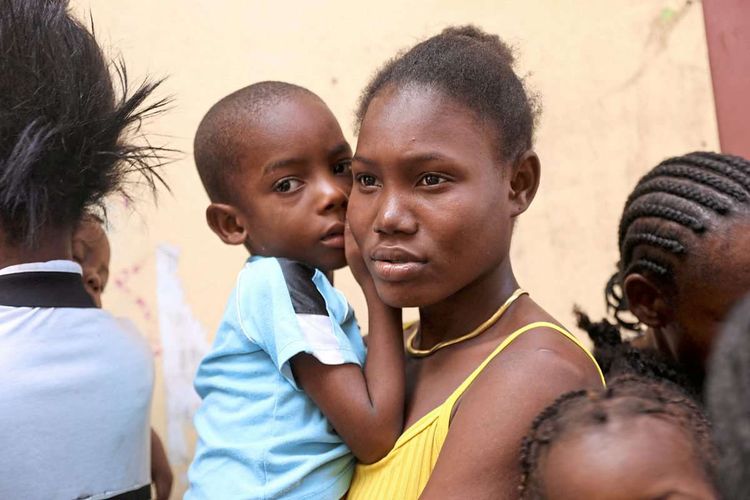 Haitianische Frau mit Kind im Arm