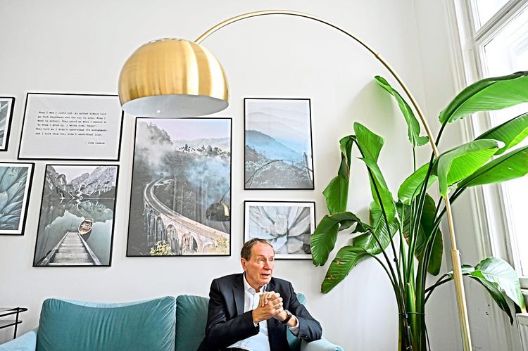 Gerald Grohmann, Vorstandschef von Schoeller-Bleckmann Oilfield Equipment, vor einer Wand mit Fotos, auf einem Sofa sitzend.