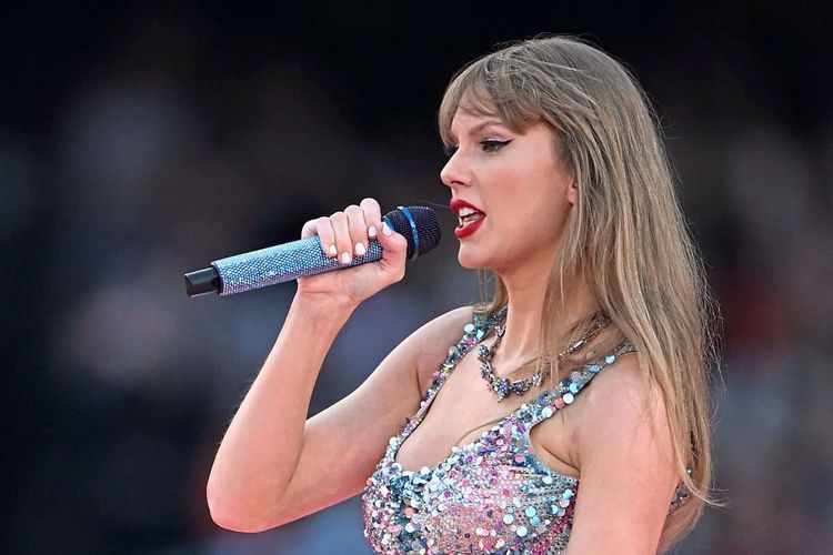 Taylor Swift mit Mikrofon live im Konzert