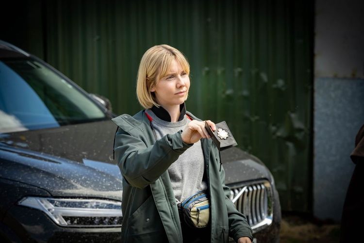 Detective Sergeant Karen Pirie (gespielt von Lauren Lyle) zeigt ihren Polizei-Ausweis.
