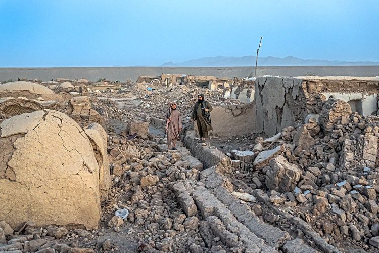 Afghanen gehen durch zerstörtes Dorf nach Erdbeben