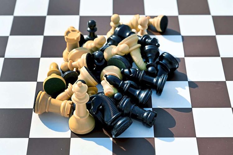 Schachfiguren, die auf einem Haufen auf einem Schachfeld liegen.