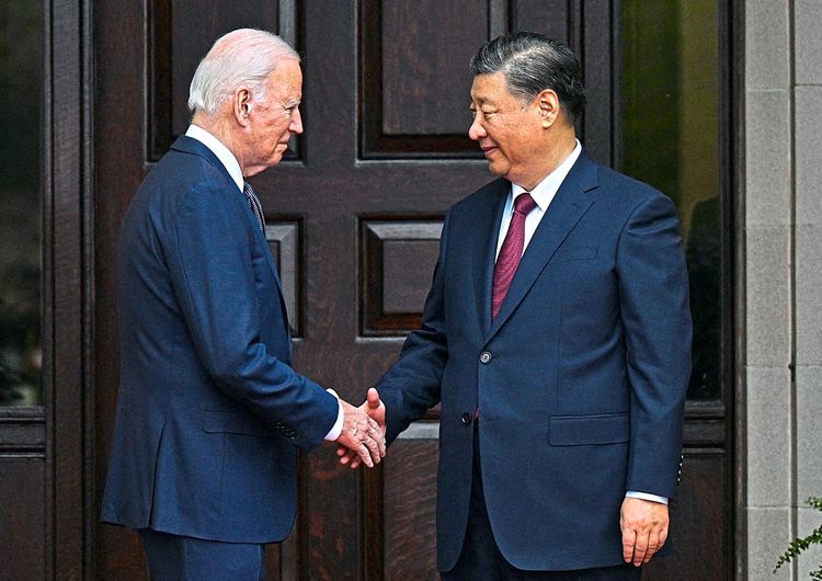Biden schüttelt Xi die Hand. Beide tragen einen Anzug.