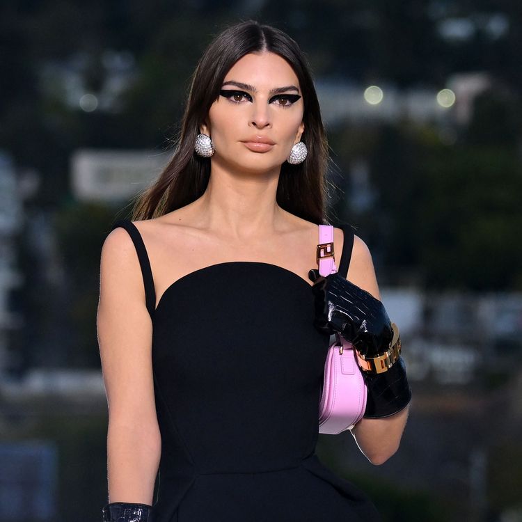 Model Emily Ratajkowski trägt eine roséfarbene Handtasche eng am Körper während der Versace-Show in Los Angeles.