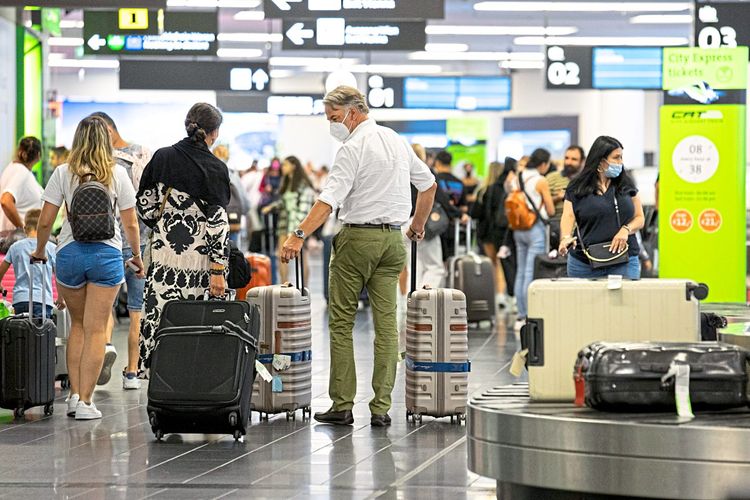Menschen bei der Gepäckausgabe des Wiener Flughafens.