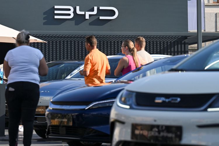 Auf der Automesse IAA in München sind mehrere Modelle von Chinas BYD-Autos zu sehen und Menschen, die diese Autos ansehen.