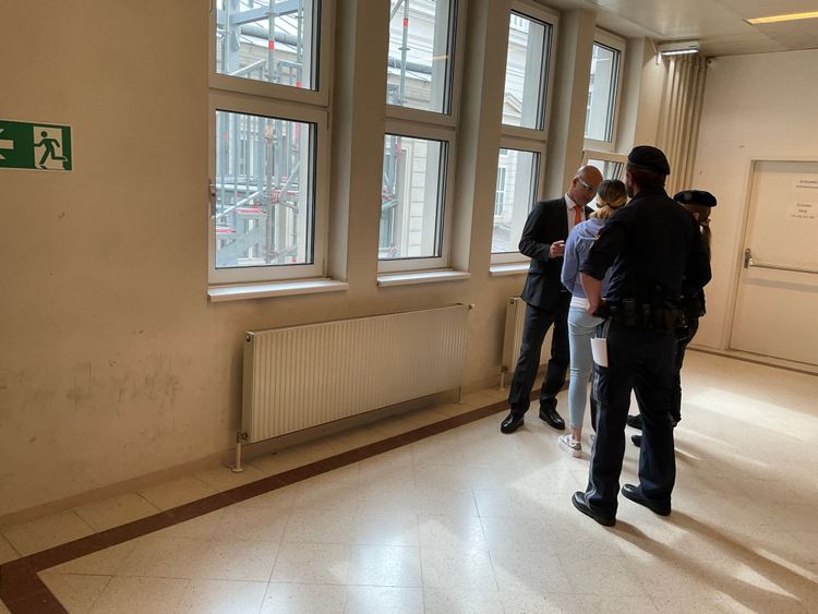 Verteidiger Nikolaus Rast steht mit seiner aus der Untersuchungshaft vorgeführten Mandantin und zwei Justizwachebeamten auf dem Gang des Landesgerichts für Strafsachen Wien.