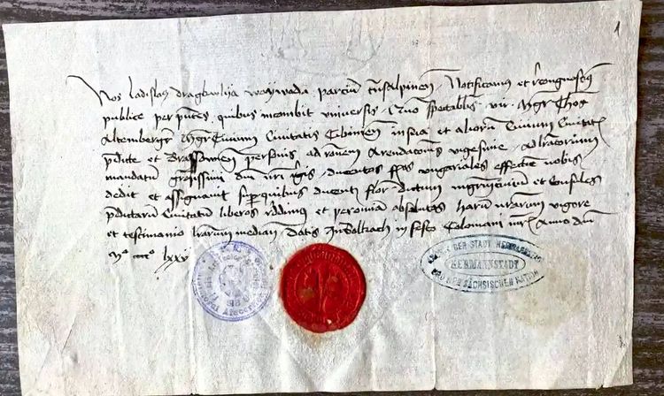 Mittelalterlicher Brief von Vlad Tepes in schwungvoller Schrift, unter dem neunzeiligen Text in dunkler Tinte sieht man ein rotes Siegel und zwei Stempel.