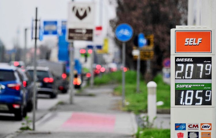 Anzeigetafel einer Tankstelle in Monza, Norditalien, mit aktuellen Kraftstoffpreisen am 11. März 2026: Diesel kostet 2,079 €/Liter, Super (bleifrei) 1,859 €/Liter. Im Hintergrund sind eine Straße, Fahrzeuge und Verkehrsschilder sichtbar.