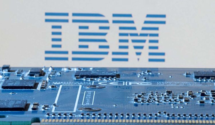Das Bild zeigt ein IBM-Logo hinter dem Motherboard eines Computers.
