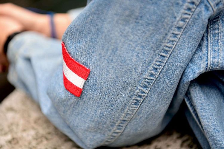 Rot-weiß-rote Fahne auf Jeansjacke Symbolbild für Einbürgerungen
