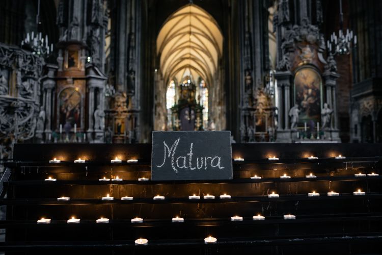 Ein Blick in das Schiff des Stephansdoms in Wien, im Zentrum ein Kerzenständer, auf dem ein Schild steht, auf das mit Kreide 