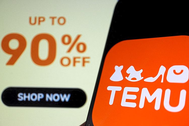 Das Logo von Temu, einer E-Commerce-Plattform im Besitz von PDD Holdings, ist auf einem Mobiltelefon zu sehen, das vor der Website des Unternehmens steht.