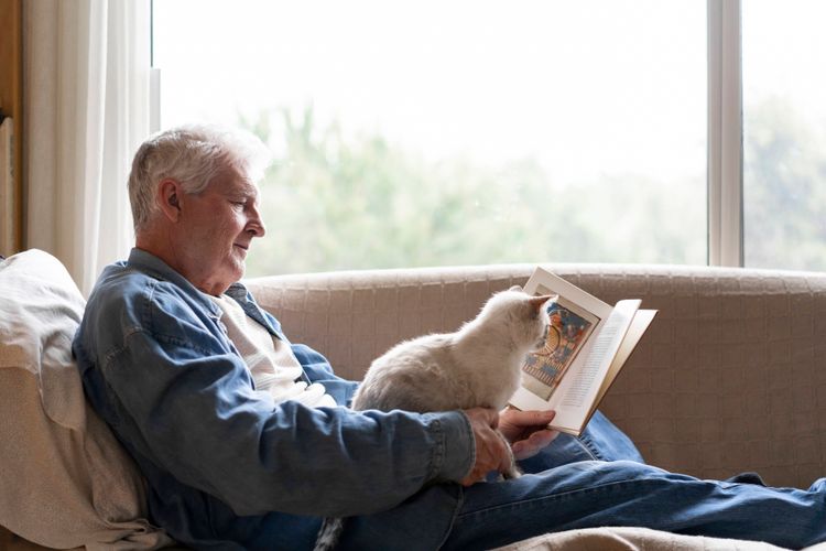 Pensionist mit Katze und Zeitung