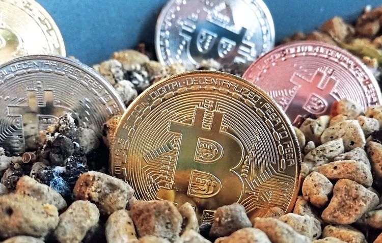 Bitcoin-Symbolmünzen in Gold, Silber und Bronze.
