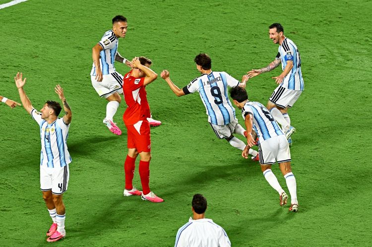 Argentinische Fußballspieler, darunter mit der Nummer 9 und 10, jubeln gemeinsam über ein Tor im Viertelfinale der FIFA-Weltmeisterschaft 2026 gegen die Schweiz. Ein Schweizer Spieler zeigt Enttäuschung. Im Hintergrund ist ein grüner Rasen zu sehen.