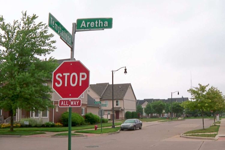Stop-Schild an einer leeren Kreuzung, dahinter Einfamilienhäuser