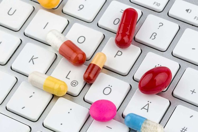 Auf einer Computertastatur liegen verschiedene Tabletten.