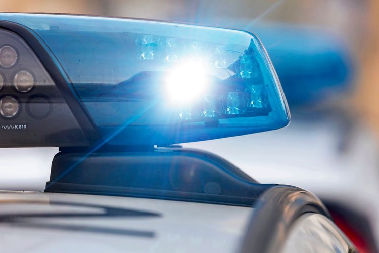 Nahaufnahme eines eingeschalteten Blaulichts auf einem Polizeiauto, symbolisch für einen Polizeieinsatz.