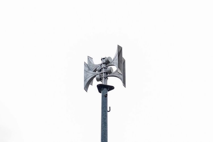 Eine silberne Sirenenanlage auf einem hohen Mast vor einem weißen Himmel, aufgenommen auf dem Gelände der Feuerwehr im Landkreis Peine, Niedersachsen, Deutschland.