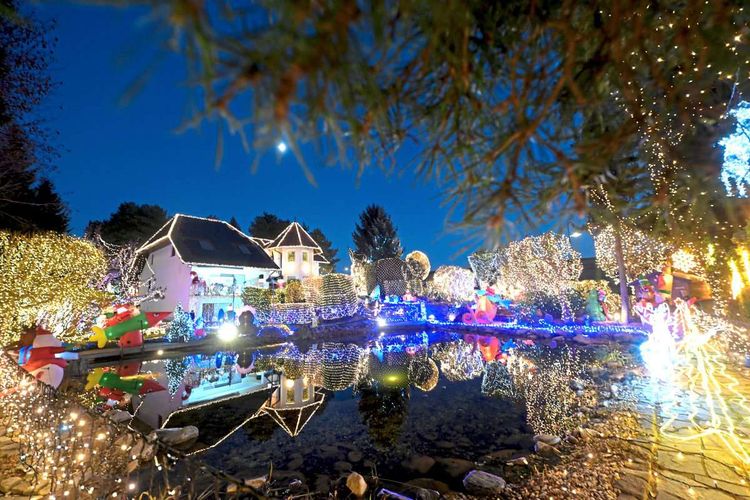 Weihnachtshaus voll beleuchtet, Reflexion im Schwimmteich