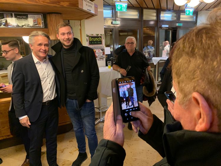 Peter Westenthaler macht Selfies mit FPÖ-Sympathisanten vor einer Theke.