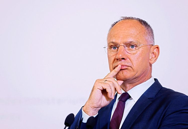 Innenminister Gerhard Karner hält sich mit ernstem Gesichtsausdruck einen Finger an die Lippen.